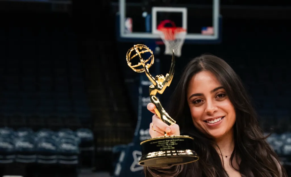 Woman holding Emmy Award on basketball court