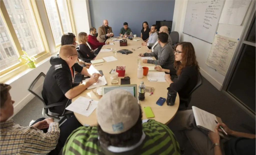 A group of people photographed talking in a meeting