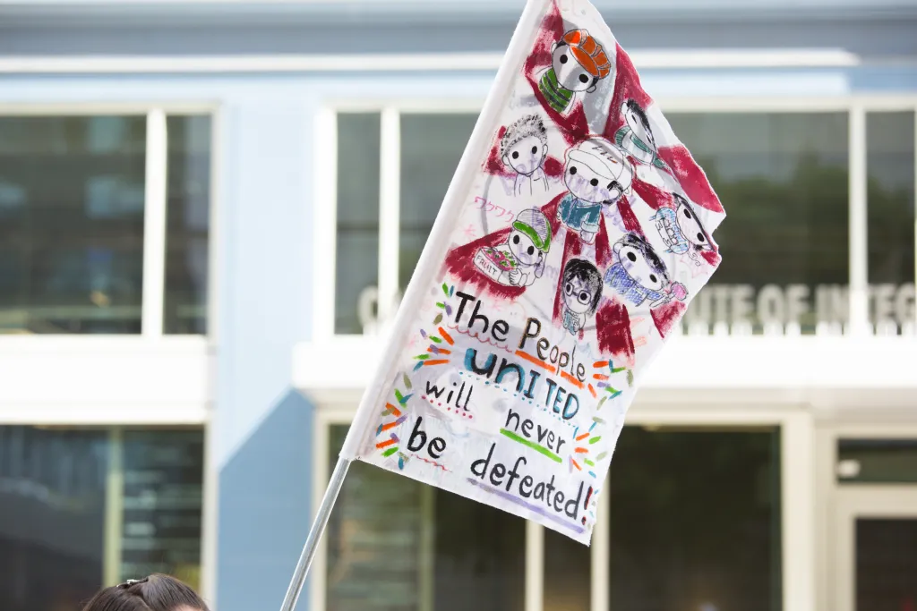 Flag with the words "people united will never be defeated"