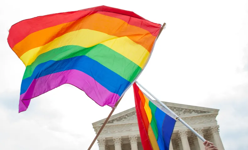 Two rainbow flags fly across the Supreme Court of the United States of America