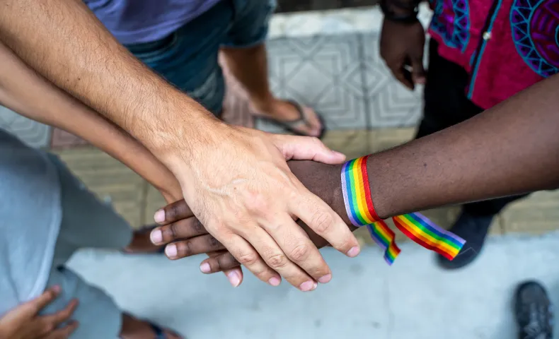 Hands in the center with rainbow bracelet