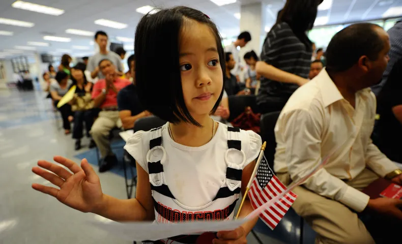 Young girl at citizenship ceremony holding flag