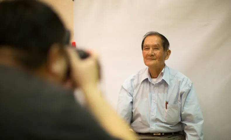 Elderly man getting his photo taken at naturalization fair