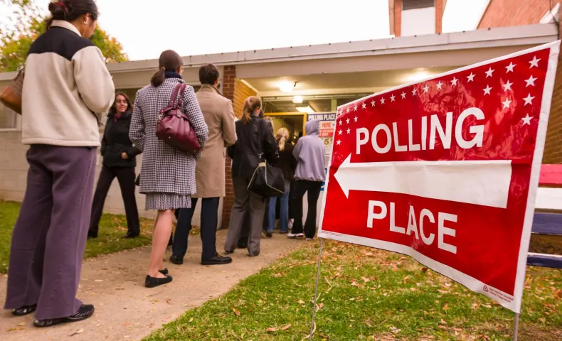 Voting polling place sign and people lined up on presidential election day.