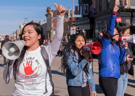 Two women with megaphones at a rally for immigrant rights