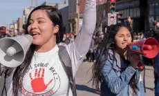 Two women with megaphones at a rally for immigrant rights