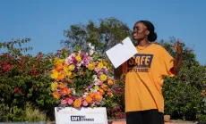 Justice Action Center Communications Coordinator Joan Agoh speaks at a #SafeNotStranded rally at San Diego’s Balboa Park