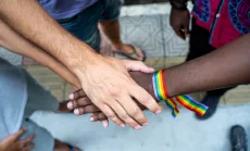 Hands in the center with rainbow bracelet 