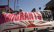 May Day March marchers holding sign