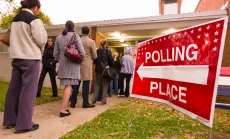 Voting polling place sign and people lined up on presidential election day.