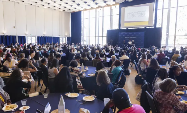 Large audience seated at round tables in a conference hall, listening to speakers on stage at the Berkeley Public Policy Annual Conference and Alumni Gathering 2023.