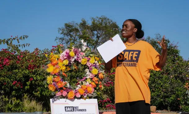 Justice Action Center Communications Coordinator Joan Agoh speaks at a #SafeNotStranded rally at San Diego’s Balboa Park