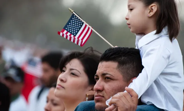 Girl with flag on father's shoulders