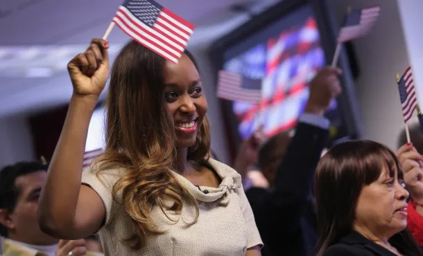 Woman waves flag at citizenship ceremony