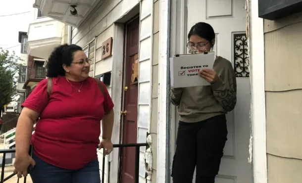 Young woman seen registering to vote at the door of her home