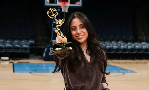 Woman holding Emmy award on basketball court