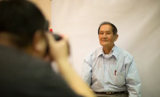 Elderly man getting his photo taken at naturalization fair