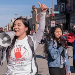 Two women with megaphones at a rally for immigrant rights