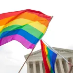 Two rainbow flags fly across the Supreme Court of the United States of America