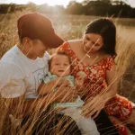 A family photographed sitting in a field.