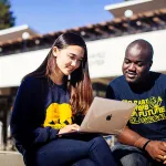 Two students at University of California, Berkeley looking at a laptop together.