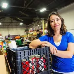 Young woman volunteering in food bank warehouse