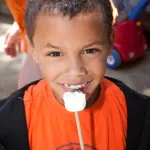 Boy eating marshmallow at Presidio Rob Hill Campground