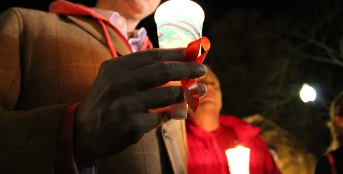 Man holding candle at World Aids Day