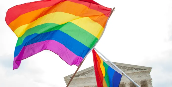 Two rainbow flags fly across the Supreme Court of the United States of America