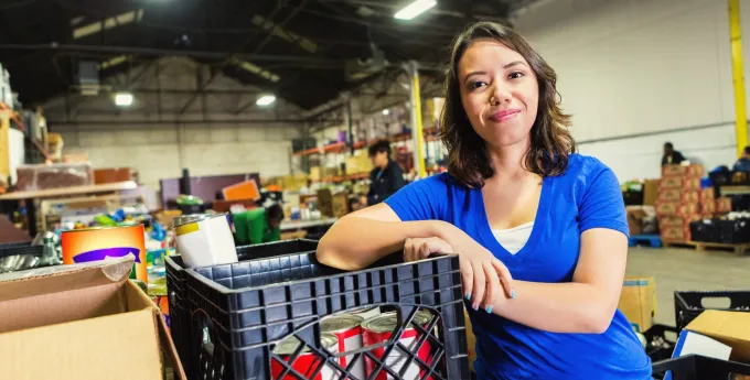 Young woman volunteering in food bank warehouse