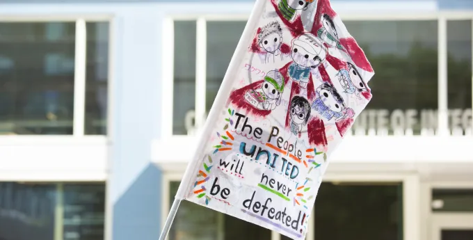 Flag with the words "people united will never be defeated"