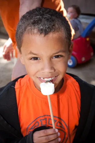 Boy eating marshmallow at Presidio Rob Hill Campground